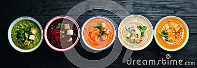 Colored vegetable soup cream. Dietary food. On a black background. Top view. Stock Photo