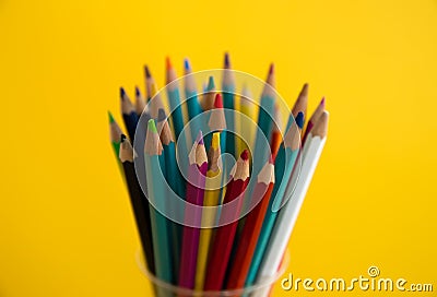 Colored wooden pencils for drawing in a glass stand on a white background. Children`s multi-colored pencils for drawing Stock Photo