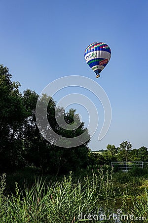 Colorful air balloon flies over the city suburbs. Editorial Stock Photo