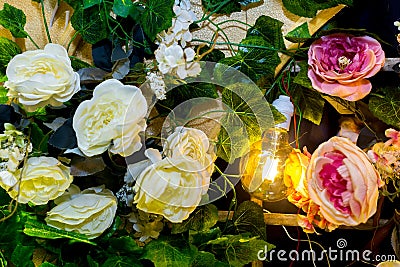 Colorful artificial flowers with Decorative antique Edison style filament light bulbs Stock Photo