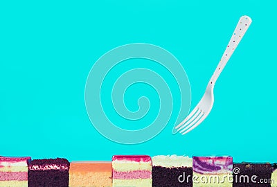 Colorful bakery slice with fork on blue background.Food and healthy concepts Stock Photo