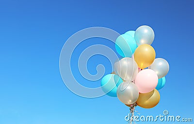 Colorful balloons against clear blue sky on sunny day Stock Photo