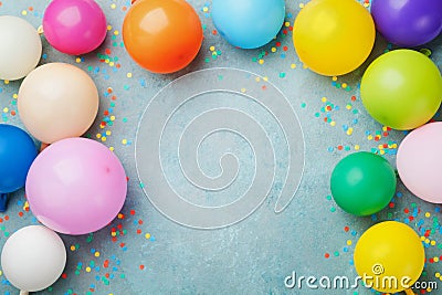 Colorful balloons and confetti on blue table top view. Festive or party background. Flat lay style. Birthday greeting card. Stock Photo