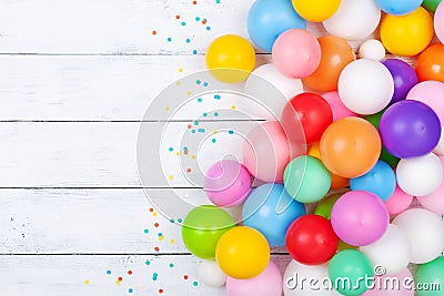 Colorful balloons and confetti on white table top view. Festive or party background. Flat lay. Birthday greeting card Stock Photo