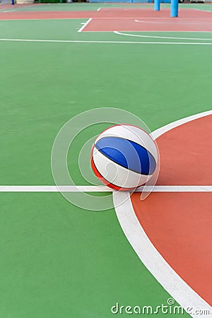 Colorful basketball ball on the guide lines of outdoor court Stock Photo