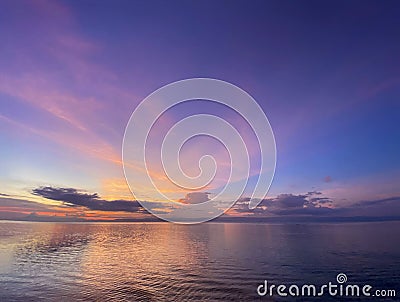 Colorful beautiful sunset, dawn with shades of pink, purple, blue. Calm sea with reflection of clouds in the water. Stock Photo
