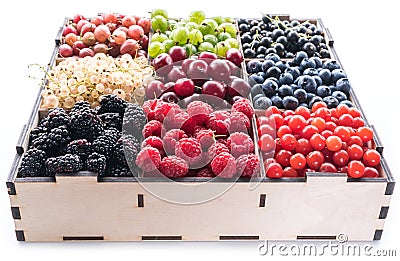Colorful berries in wooden box on white background. Close-up Stock Photo