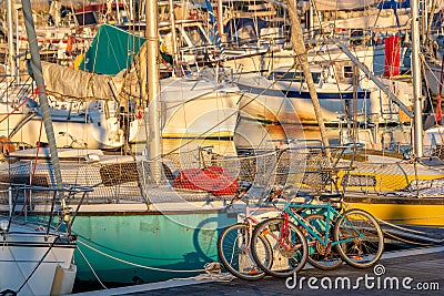 Colorful bicycles and sailing boats at sunset in the harbor of La Rochelle France Stock Photo