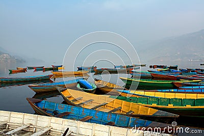 Colorful boats symbol of Phewa lake shore with fog in the morning,Nepal. Stock Photo