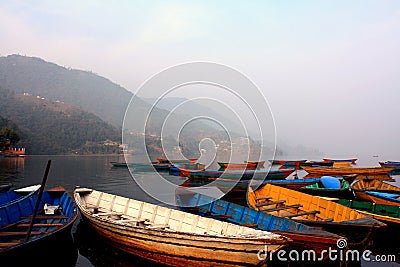 Colorful boats symbol of Phewa lake shore with fog in the morning in Nepal. Stock Photo