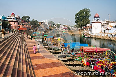 Colorful boats wait for the passengers at the river docks of indian city Editorial Stock Photo