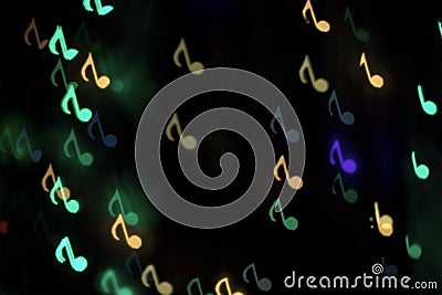 Colorful bokeh on a dark background in the form of musical notes Stock Photo
