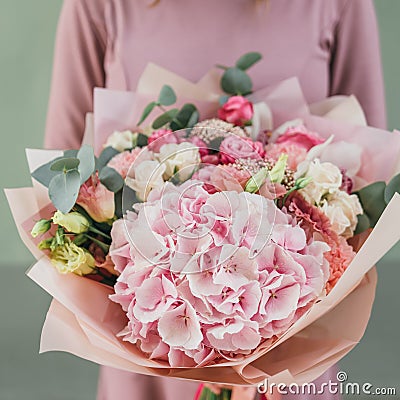 Colorful bouquet of different fresh flowers in the hands of florist woman. Rustic flower background. Craft bouquet of Stock Photo