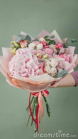 Colorful bouquet of different fresh flowers in the hands of florist woman. Rustic flower background. Craft bouquet of Stock Photo