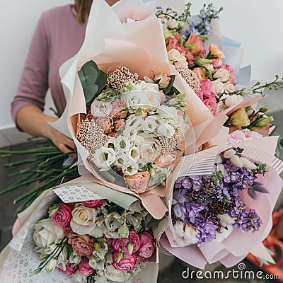 Colorful bouquet of different fresh flowers in the hands of florist woman. Rustic flower background. Craft bouquet of Stock Photo