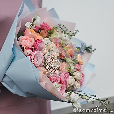 Colorful bouquet of different fresh flowers in the hands of florist woman. Rustic flower background. Craft bouquet of Stock Photo