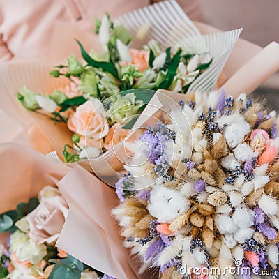 Colorful bouquet of different fresh flowers in the hands of florist woman. Rustic flower background. Craft bouquet of Stock Photo