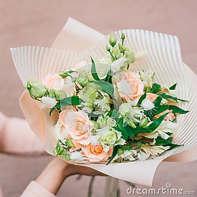 Colorful bouquet of different fresh flowers in the hands of florist woman. Rustic flower background. Craft bouquet of Stock Photo