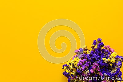 Colorful bouquet of dried autumn flowers lying on yellow paper background. Copy space. Flat lay. Top view. Stock Photo