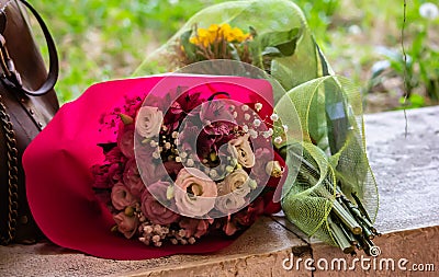 Colorful bouquets of flowers to pay homage to someone resting on a stone plain Stock Photo