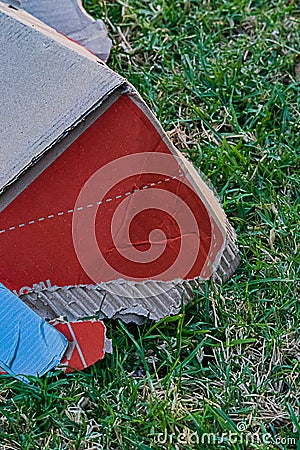 A colorful box littering a public street lawn torn, shabby Stock Photo