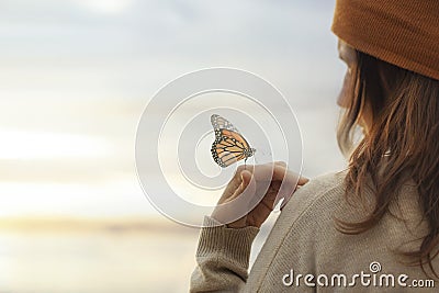 Colorful butterfly is laying on a woman`s hand Stock Photo