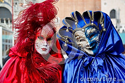 Colorful carnival pair red-blue mask and costume at the traditional festival in Venice, Italy Editorial Stock Photo