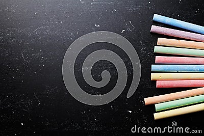 Colorful chalks on blackboard for back to school theme. Stock Photo