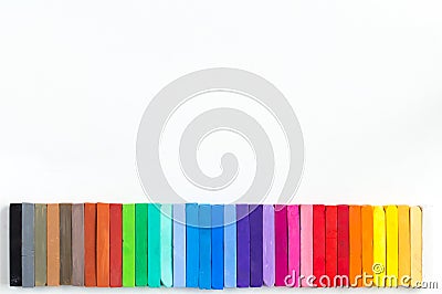 Colorful chalks lined up on white background Stock Photo