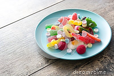 Colorful childs sweets and treats in plate on wood Stock Photo