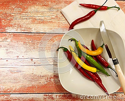Colorful chili peppers on orange wooden background ... Stock Photo