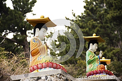 Colorful chinese god figure and deity angel buddha statue on stone stairs go to Sanbangsan mountain for korean people travelers Stock Photo