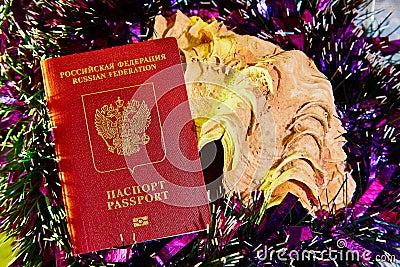 Colorful Christmas tinsel, passport citizen of Russia and big shell Stock Photo