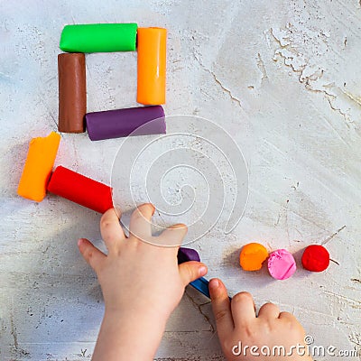 Colorful clay plasticine, modelling clay placed like square with child`s hands, square, education, child psychology Stock Photo