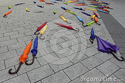 Colorful closed umbrellas scattered on the sidewalk Stock Photo