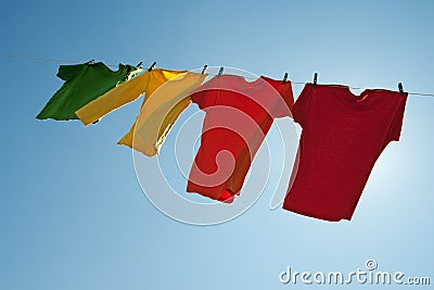 Colorful clothes hanging to dry in the blue sky Stock Photo