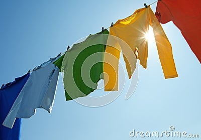 Colorful clothes on a laundry line and sun shining Stock Photo