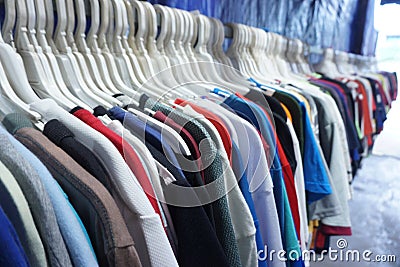 Colorful clothes on multiple hangers in a clothing secondhand store Stock Photo