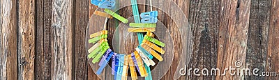 colorful clothespins hang on a wooden fence Stock Photo