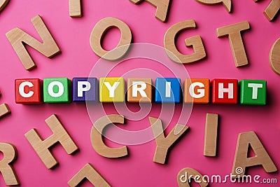 Colorful cubes with word Copyright and wooden letters on dark pink background, flat lay. Plagiarism concept Stock Photo