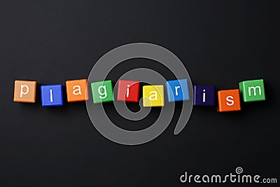 Colorful cubes with word Plagiarism on black background, flat lay Stock Photo