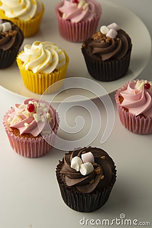 Colorful cupcakes on a white background. Pink, yellow and chocolate cupcakes. Party food. Sweet dessert or breakfast. Party, Stock Photo