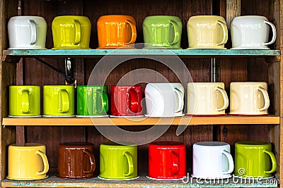 Colorful cups on shelf Stock Photo