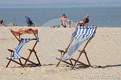 Colorful deckchairs on beach Stock Photo