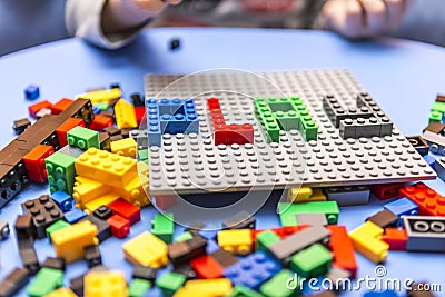 Child arranges block of constructor. a childhood game that develops the imagination of small people. Editorial Stock Photo