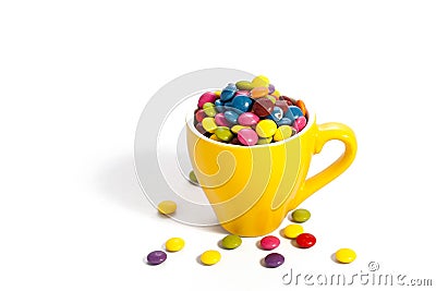 Colorful dragees in yellow cup Stock Photo