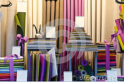 The colorful drapery shop window with fabric rolls and stacks of different shapes and colors Stock Photo