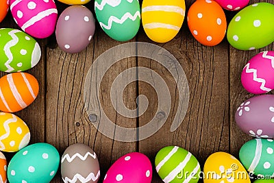 Colorful Easter egg frame against a rustic wood background Stock Photo