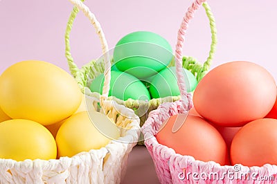 Colorful Easter eggs in colored baskets. Pink background. Easter holiday concept Stock Photo