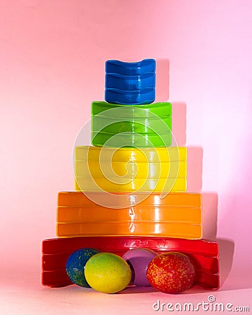 colorful easter eggs next to plastic rainbow, creative holiday design, children time Stock Photo